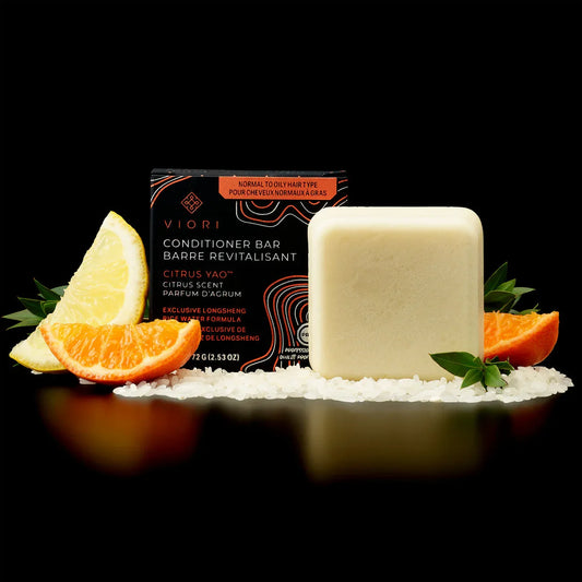 Viori Citrus Yao conditioner bar with citrus fruit slices and rice grains on black background